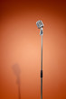 Vintage microphone against brown background.