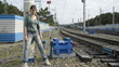 Young woman standing at the pillar on the railroad