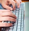 Male hands typing on a laptop keyboard