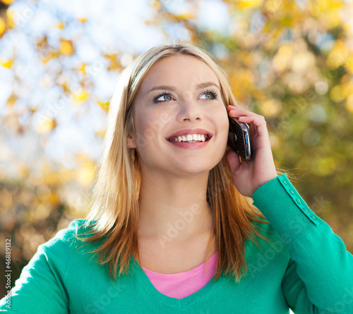 Photo: Woman using mobile phone outdoors Woman using mobile phone outdoors