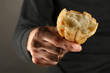 homeless man holding a white bread, close-up
