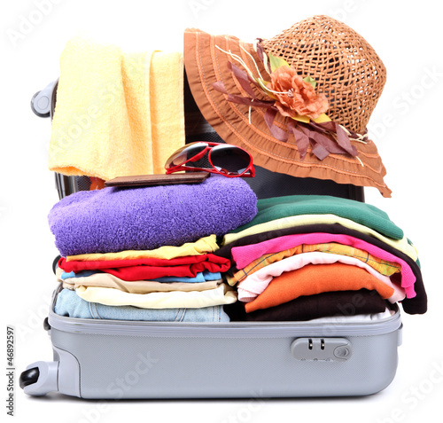 Photo: Open silver suitcase with clothing isolated on white Open silver suitcase with clothing isolated on white