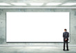Business person standing near a blank billboard