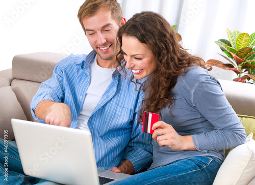Photo: Young couple with Laptop and Credit Card buying online Young couple with Laptop and Credit Card buying online