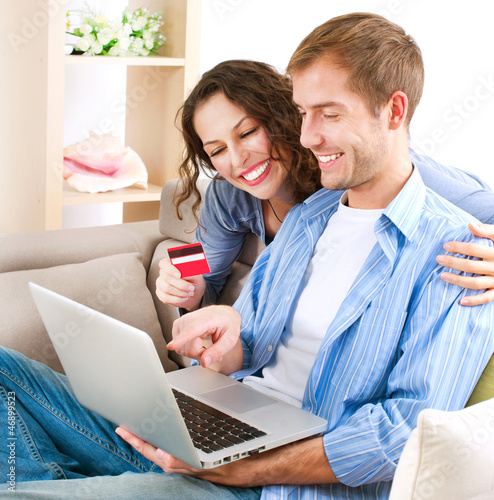 Photo: Young couple with Laptop and Credit Card buying online Young couple with Laptop and Credit Card buying online