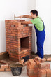 Worker building a brick stove
