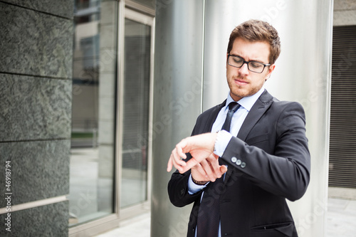 Photo: Businessman checking time on his watch Businessman checking time on his watch