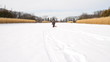 Little boy walking across white snow field with red sled