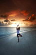 Foto: Yoga woman on beach at sunset Yoga woman on beach at sunset