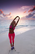Foto: Woman stretching on beach Woman stretching on beach