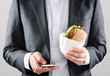 Man in suit sending sms while getting take away lunch