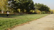 Businesswoman walking in autumn park with a cloak in the hands