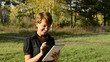 Young woman enjoys the Internet in the autumn park
