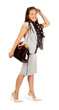 Smiling business woman walks with bag in studio on white