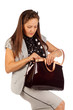 Business woman searches for something in big bag in studio