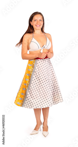 Photo: Beautiful woman dressed in bikini and skirt smiles in studio Beautiful woman dressed in bikini and skirt smiles in studio