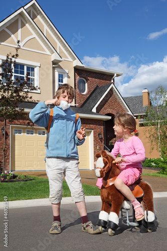 Photo: girl rides at toy horse and boy eats cotton candy girl rides at toy horse and boy eats cotton candy