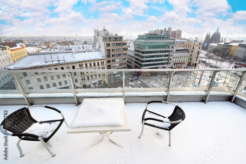 Photo: Table and chairs on balcony in snow at winter. Table and chairs on balcony in snow at winter.