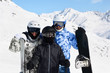 Happy family in sport suits and helmets stand with snowboard