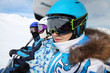 Three skiers in special clothing and helmets ride on cable car