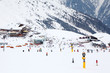 Many skiers ride at mountain. Cable car, hotels in Alps