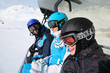 smiling skiers in helmets and goggles ride on funicular