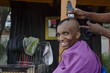 Smiling customer at African small haircut barber business