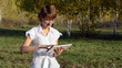 Young woman running on a Tablet PC in the autumn park