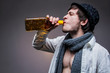 Fashionable guy in a hat drinking tequila