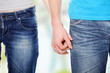 Closeup of young couple holding hands