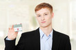 Photo: Young business man holding house model Young business man holding house model