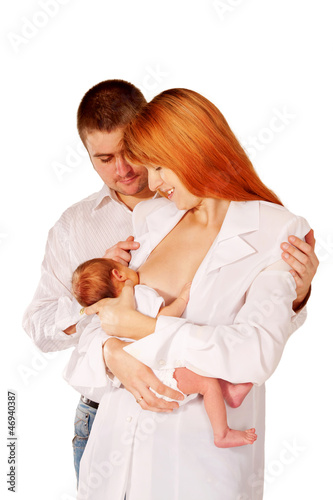 Photo: Happy family, father mother and baby. Mom breast feeding newborn Happy family, father mother and baby. Mom breast feeding newborn