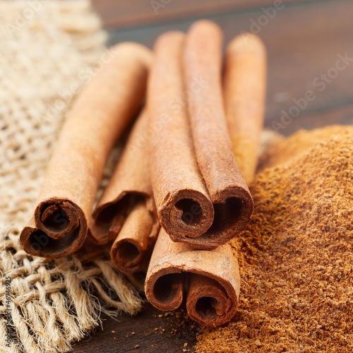 Photo: Cinnamon sticks and powder in wooden scoop Cinnamon sticks and powder in wooden scoop