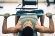 Photo: Young man lifting the barbell in the gym. Young man lifting the barbell in the gym.