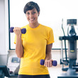Photo: Young girl exercising with dumbbells in the gym. Young girl exercising with dumbbells in the gym.