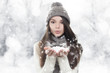 Photo: Winter portrait. Young, beautiful woman blowing snow Winter portrait. Young, beautiful woman blowing snow