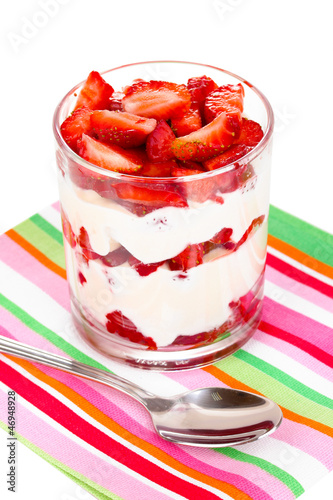 Photo: Glass of ripe strawberries with cream isolated on white Glass of ripe strawberries with cream isolated on white