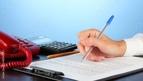 Photo: signing of a treaty, on blue background close-up signing of a treaty, on blue background close-up
