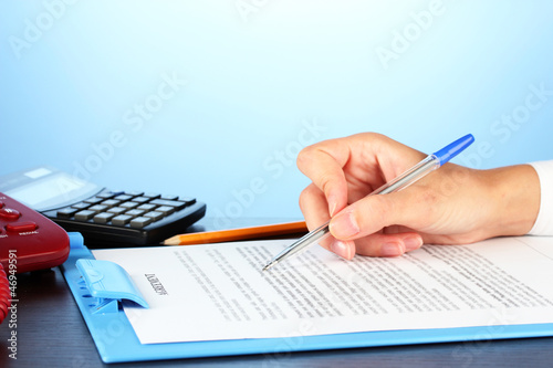 Photo: signing of a treaty, on blue background close-up signing of a treaty, on blue background close-up