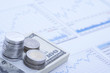 Stacks of coins and currency papers on financial paper