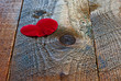 Red heart shaped rose petal on rustic wooden table
