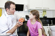 A male dentist explaining healthy eating to a young girl patient