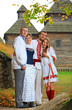 Two young couples in Ukrainian style clothing posing outdoors