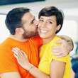 Photo: Young couple embracing and kissing at the gym. Young couple embracing and kissing at the gym.