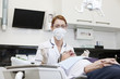 A female dentist examining a male patients teeth