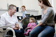 A male dentist with a little girl patient and her mother