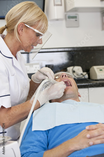 Photo: A female dentist treating her male patient A female dentist treating her male patient