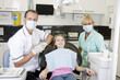 A dentist and dental nurse with a young girl patient