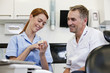 A dentist and dental nurse looking at a dental cast