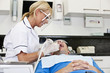 A female dentist treating her male patient